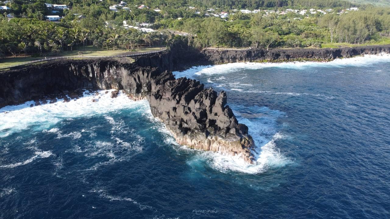 L'écume blanche qui explose sur les falaises de basalte noir de Cap Méchant, entre les vacoas.